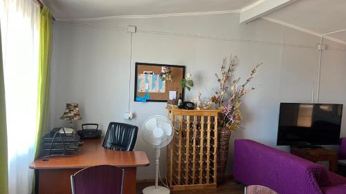 sala de estar con escritorio y TV en Ubicación central cabaña frente al mar, en Tocopilla