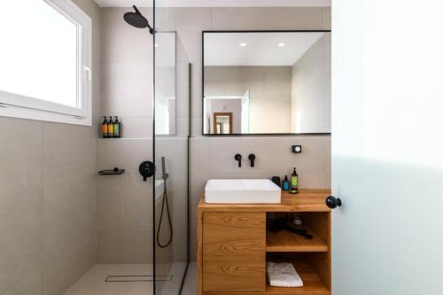 a bathroom with a sink and a shower at Azure Bliss Mykonos in Agios Stefanos