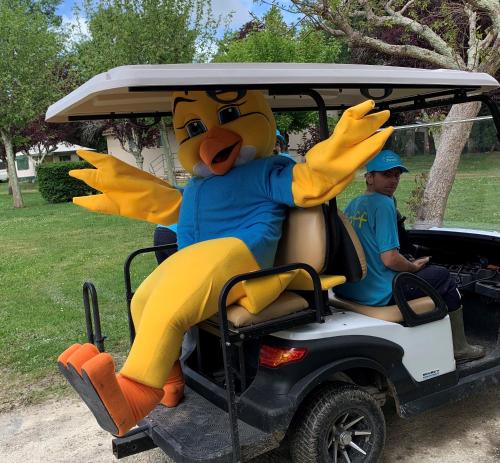 une personne déguisée en mascotte dans une voiturette de golf dans l'établissement Camping Paradis Aubeterre, à Aubeterre-sur-Dronne