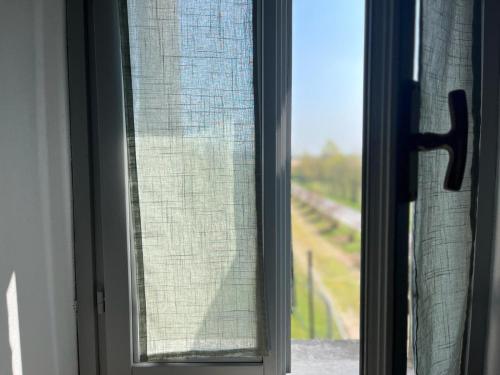 una ventana abierta con vistas a un patio de trenes en Agriturismo Il Campagnino, en Cremona