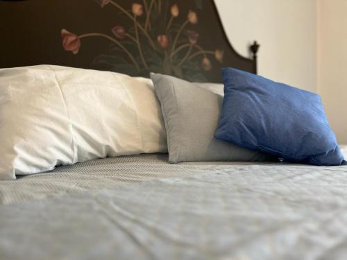 Una cama con dos almohadas azules encima. en Agriturismo Il Campagnino, en Cremona