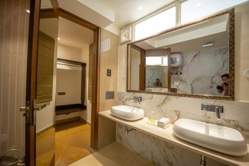 een badkamer met 2 wastafels en een grote spiegel bij ASHOK VILLA in Jaipur