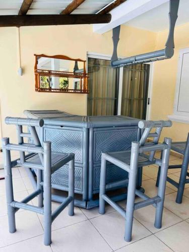 a blue desk with two chairs and a mirror at Salty Château in Cap Malheureux