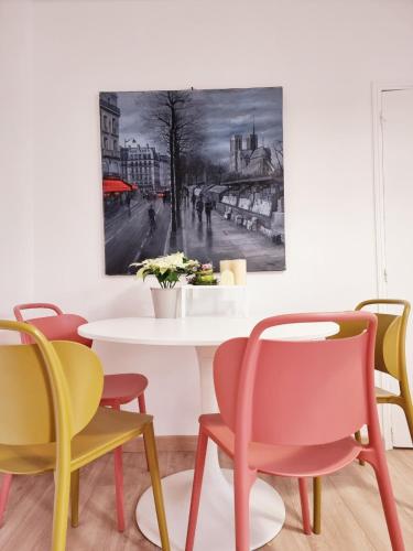 a dining room with colorful chairs and a table at in paris in Villejuif