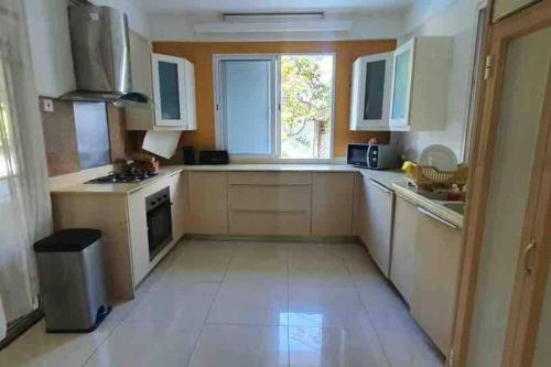 a small kitchen with white cabinets and a window at Salty Château in Cap Malheureux