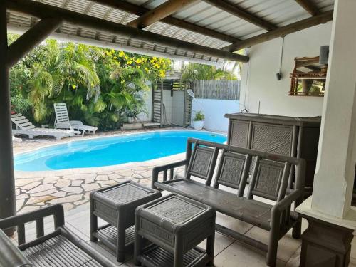 a patio with a bench and a swimming pool at Salty Château in Cap Malheureux