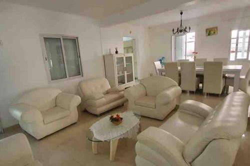 a living room with white furniture and a table at Salty Château in Cap Malheureux