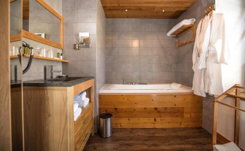La salle de bains est pourvue d'une baignoire et d'un lavabo. dans l'établissement Hôtel L'Atelier de Donat, à Malbuisson