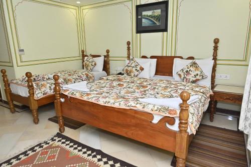 a bedroom with two beds and a rug at Hotel Rime Vista in Jaipur