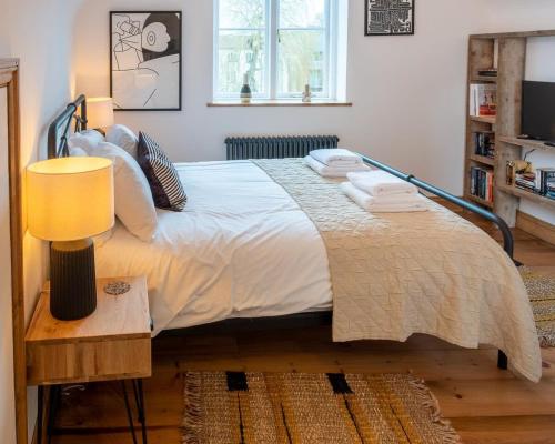 Un dormitorio con una cama grande y una mesa con una lámpara. en Stylish Quayside Apartment with River View en Norwich