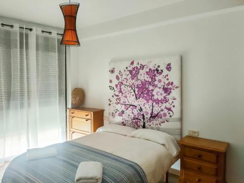 トレドにあるEl rincon de Toledoの壁に絵が飾られたベッドのある寝室