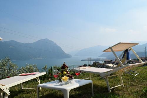 two picnic tables with wine glasses on top of a hill at Villa Domus Bianca Mountain Lake Iseo Hospitality in Costa Volpino