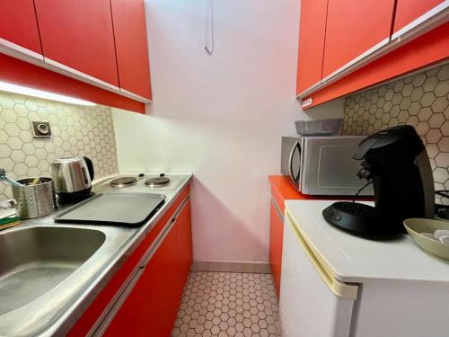 une petite cuisine avec un évier et un micro-ondes dans l'établissement STELA - Studio cœur de Reims, à Reims