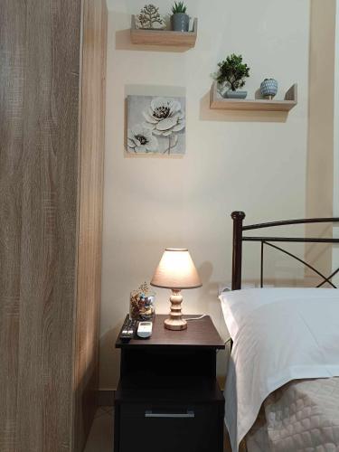 a bedroom with a bed and a lamp on a night stand at Lagadas Shiny apartments in Mytilini