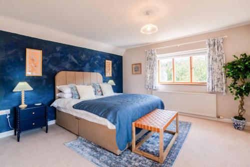 una camera con letto e parete blu di Tree Tops House a Cheltenham