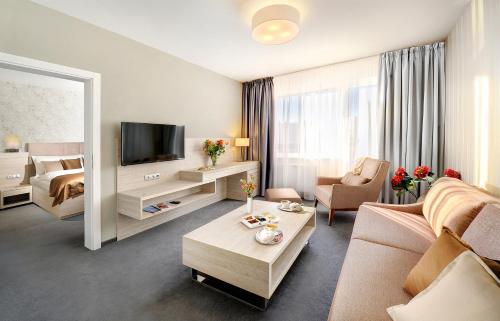 a living room with a couch and a tv at Hotel Park in Dolný Kubín