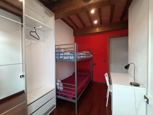 a room with a bunk bed and a red wall at The Twin House in Lucca