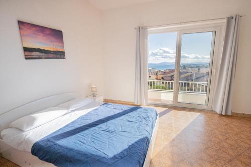 Dormitorio blanco con cama y ventana grande en Tramontana vista mare 300m dalla spiaggia, en Golfo Aranci