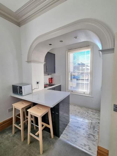 a kitchen with a counter and stools in a room at Entire Apartment by City Centre & Harbourside in Bristol