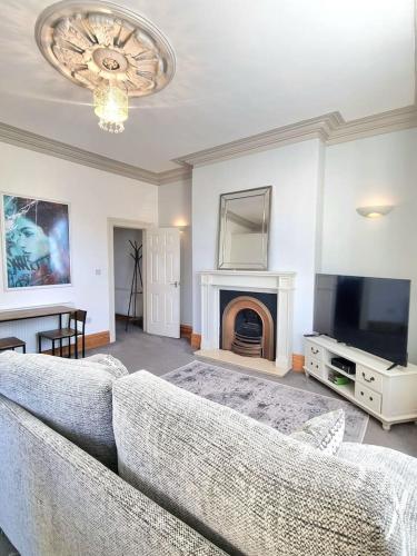 a living room with a couch and a tv and a fireplace at Entire Apartment by City Centre & Harbourside in Bristol