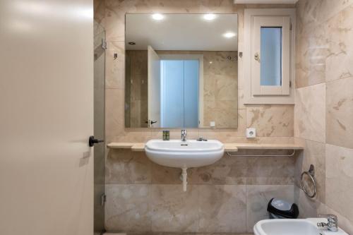 y baño con lavabo y espejo. en Flateli Pou Rodó 3, en Girona