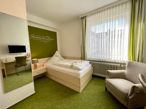 Habitación de hotel con cama, silla y ventana en Gästehaus Schmidt en Bad Lippspringe
