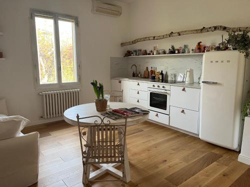 a kitchen with a table and a white refrigerator at Bloom as you are in Bologna