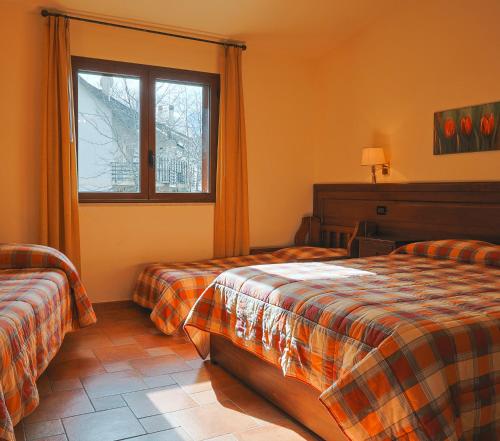 a hotel room with two beds and a window at Park Hotel Bellavista in Gambarie dʼAspromonte