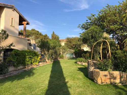 une ombre d'une maison sur une pelouse dans l'établissement Gîte : La cave des Violettes, à Lespignan