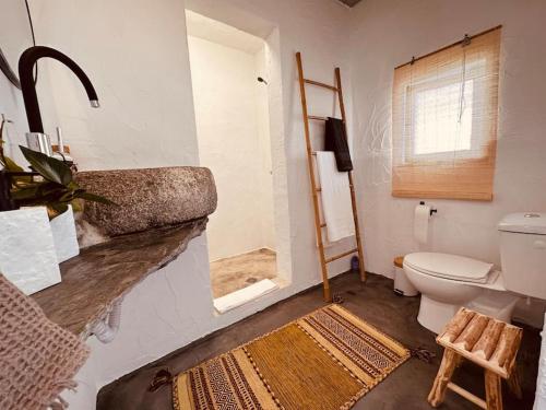 ein Bad mit einem Waschbecken, einem WC und einem Fenster in der Unterkunft Paraíso do Corval in São Pedro do Corval