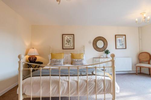 sypialnia z łóżkiem, lampką i krzesłem w obiekcie Garden Cottage w mieście Cheltenham