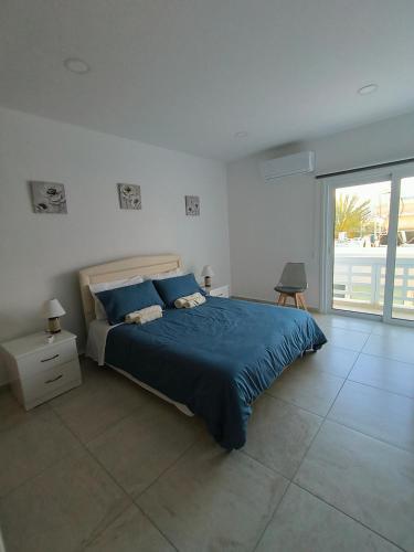 a bedroom with a bed with a blue comforter at Larnaca BeachHouse in Larnaka