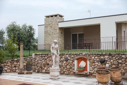 a statue of a man standing in front of a stone wall at La Rondinella Apartments in Bardolino