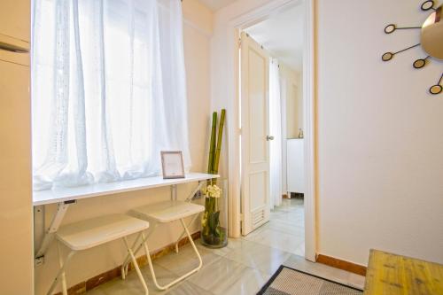een kamer met een tafel en twee stoelen en een raam bij Acogedor y coquetísimo apartamento de diseño muy, muy, muy Centrico in Sevilla