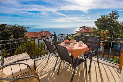 een tafel en stoelen op het balkon van een huis bij Camelia & Martina apartments in Opatija