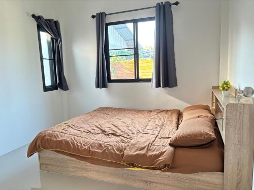 a bed in a bedroom with a window at บ้านม่วนใจ๋สันกำแพง in San Kamphaeng
