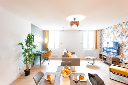een woonkamer met een bank en een tafel bij L'Escale Ocre - 150m Restaurant 3 étoiles in Vonnas