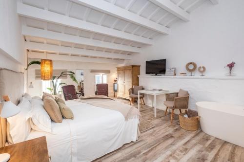 een slaapkamer met een bed, een bad en een wastafel bij Encant de Alaior Boutique Hotel in Alaior