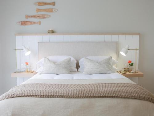 a white bedroom with a large white bed with pillows at Good Karma in Swakopmund