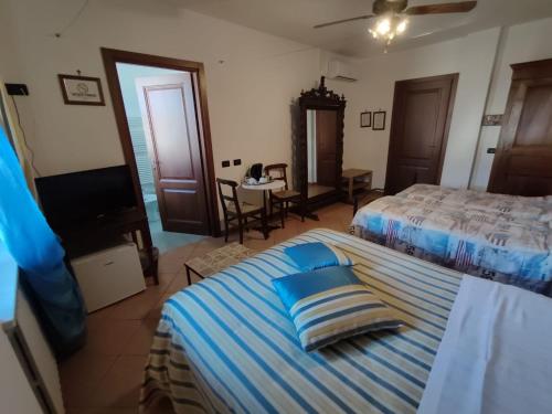 a bedroom with two beds and a television in it at Al Calar Della Sera in Sommariva del Bosco