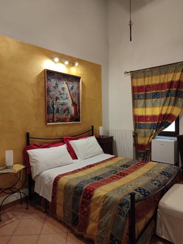 a bedroom with a bed and a painting on the wall at Al Calar Della Sera in Sommariva del Bosco