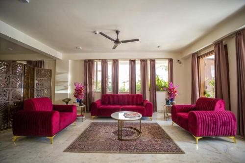 a living room with two red couches and a table at ASHOK VILLA in Jaipur