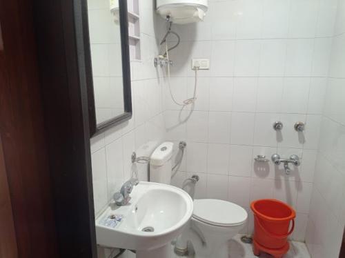 La salle de bains est pourvue d'un lavabo, de toilettes et d'un miroir. dans l'établissement Pinez Guest House , Anantnag, à Anantnāg