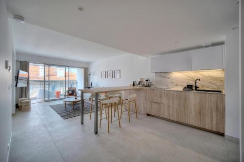 une cuisine avec des armoires en bois et une table et des chaises dans l'établissement Spacieux et confortable 2 pieces A1B259, à Cannes