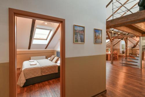 ein Schlafzimmer mit einem Bett und einer Treppe in einem Zimmer in der Unterkunft Amazing Charles Bridge Apartment in Prag