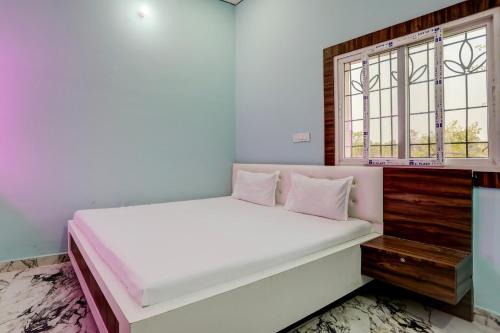 um quarto com uma cama e uma janela em Super OYO Shivansh banquet and hotel em Dhanbad