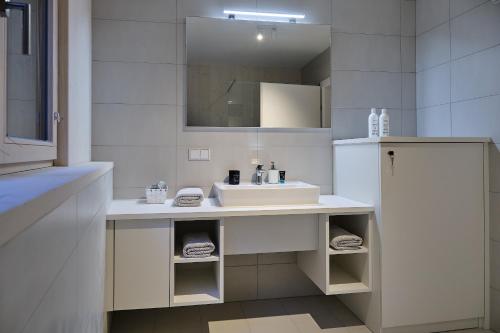 a white bathroom with a sink and a mirror at Haus Fünf mit 2 Apartments und Studio-Loft mit Terrasse in Melk