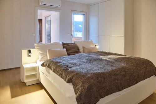 a bedroom with a large bed with a brown blanket at Haus Fünf mit 2 Apartments und Studio-Loft mit Terrasse in Melk