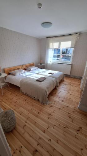 1 dormitorio con 1 cama grande y suelo de madera en Kadrina St. Catharine's Guesthouse, en Kadrina