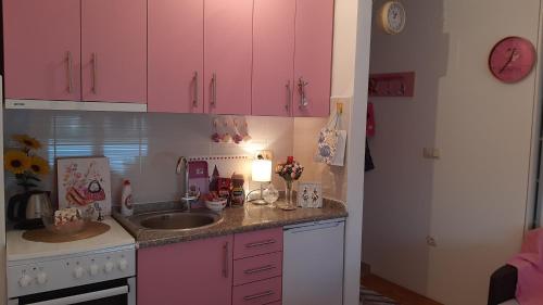 a kitchen with pink cabinets and a sink at Pink Panter Doboj in Doboj